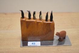 An Art Deco cocktail stick set, the bakelite holder containing six carved wooden penguin picks
