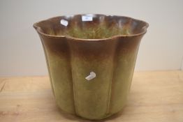 A 20th Century German lobed jardiniere, covered in a dripped green/brown glaze with maker's mark