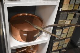 A late 19th Century French lidded copper saute pan, measuring 62cm long, together with two copper