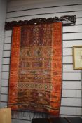 An attractive 20th Century African ceremonial textile panel, hung from a carved hardwood mount and