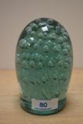 A Victorian green glass dump paperweight, having an internal controlled bubble design and ground