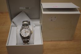 A boxed Seiko wristwatch, the white dial having gold baton numerals and date aperture, on a two-tone