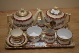 An early 20th Century Gemma crested porcelain miniature tea set, hand decorated with a red banded