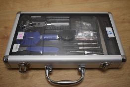 A watch repair tool kit in original box, having loupe, replacement strap bars, tweezers, various