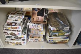 A shelf of Tamiya, Airfix, Itaileri and similar Military Kit Boxes, most started or empty, some have