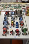 Fourteen playworn Britains, Cresent, Matchbox and similar die-cast, tin plate and plastic Tractors