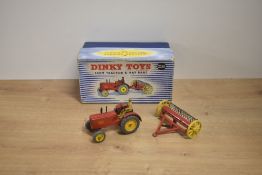 A Dinky die-cast, 27AK Farm Tractor & Hay Rake in original blue and white striped box, driver