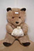 A modern Teddy Bear seated holding a Sugar Bag, height 45cm