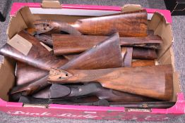 A box containing 16 old gun stocks with all metalwork removed