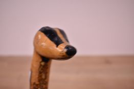 A Hazel walking stick with the top carved into a badgers head measuring 96cm long