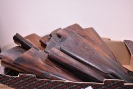 A box containing 16 old gun stocks with all metal parts removed