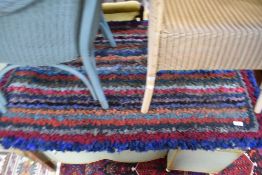 A vintage pegged rag rug in multi colour