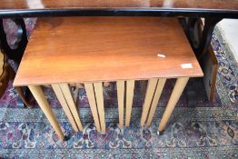 A vintage teak next of tables the mother table having tapered and castored legs with three
