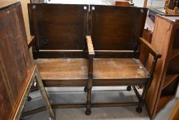An early 20th Century oak monks bench having two part top