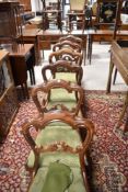 A set of six Victorian mahogany dining chairs having foliate rail backs and overstuffed drop in