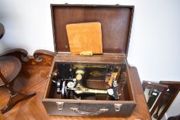 A vintage Singer sewing machine, in faux crocodile skin case