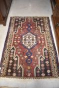 A Persian rug, having brown and burgundy ground, approx. 150 x 105cm