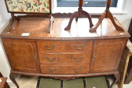 An early to mid 20th Century walnut sideboard hving three central drawers flanked by cupboards, on