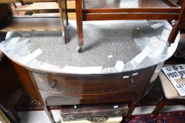 An early 20th Century bow fronted sideboard having square tapered legs on spade feet