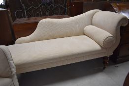 A traditional chaise longue having mahogany turned legs, with cream corduroy upholstery, approx.