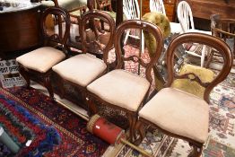 A set of four Victorian mahogany balloon back chairs having later cream upholstery