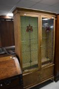 A late Victorian display cabinet having leaded glass with stained highlights, dimensions approx.
