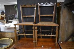 A pair of Victorian stained frame bedroom chairs having cane seats