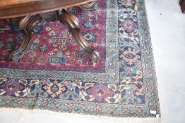 A traditional carpet square, approx 290 x 200cm, pattern quite worn, green ground