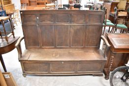 A traditional oak box settle, having panelled back, width approx. 168cm
