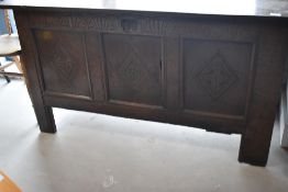 A period oak kist having carved frieze and three carved panels, dimensions approx. W140 H73 D54cm