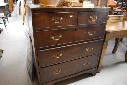 A George III oak chest of drawers, having two short and three long cockbeaded drawers, each with