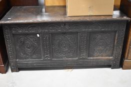 An 18th century oak three-panel coffer, of traditional design and later carved with lunettes and