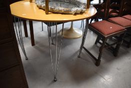 A vintage style circular kitchen table having stylised chrome legs, diameter approx. 90cm
