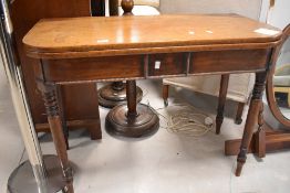 An early 19th century mahogany fold-over tea table, of rounded rectangular form, with turned
