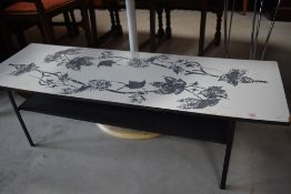 A vintage formica topped coffee table having metal frame and printed leaf design, approx. 115 x