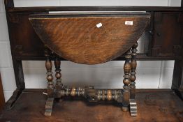 A small oak drop-leaf occasional table, having turned and gated supports 56cm