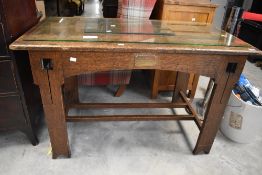 An Arts and Crafts oak table, of rectangular form with planked top over an arched rail and two