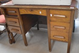 A mid 20th century oak pedestal desk with faux leather top and arrangement of seven drawers 78cm
