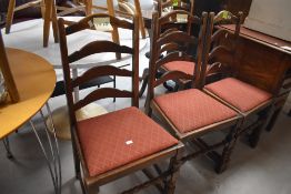 A set of four 20th century oak ladder back dining chairs, with arched rails and turned supports,