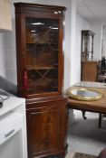 A reproduction figured mahogany double corner cupboard with astragal glazed upper section 180cm