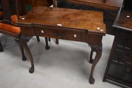 A George III carved mahogany fold-over card table, the hinged and shaped rectangular top lifting