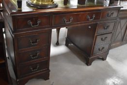 A reproduction mahogany pedestal desk, the rectangular top with inset tooled green stained leather