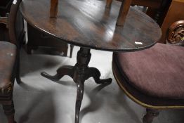 A George III oak snap-top pedestal table, the planked top over snap-top action and turned gun-barrel