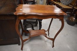 An Edwardian mahogany occasional table of moulded and shaped rectangular form with shaped and