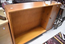 A 1960's/70's golden oak open bookcase with adjustable shelving and cupboard section to the right