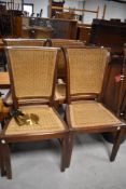 A set of four modern hardwood dining chairs with canework seats and backs