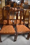 A set of four Edwardian mahogany dining chairs, the shaped top-rails with stipple craved ribbon