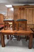 A modern stained hardwood extending dining table and four matching slat back dining chairs 76cm x
