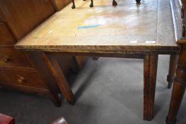 A 1940's oak draw-out dining table, of square outline with shaped supports, 74cm high