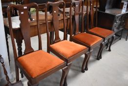 A set of four reproduction mahogany Queen Anne design dining chairs, with typical shaped splat